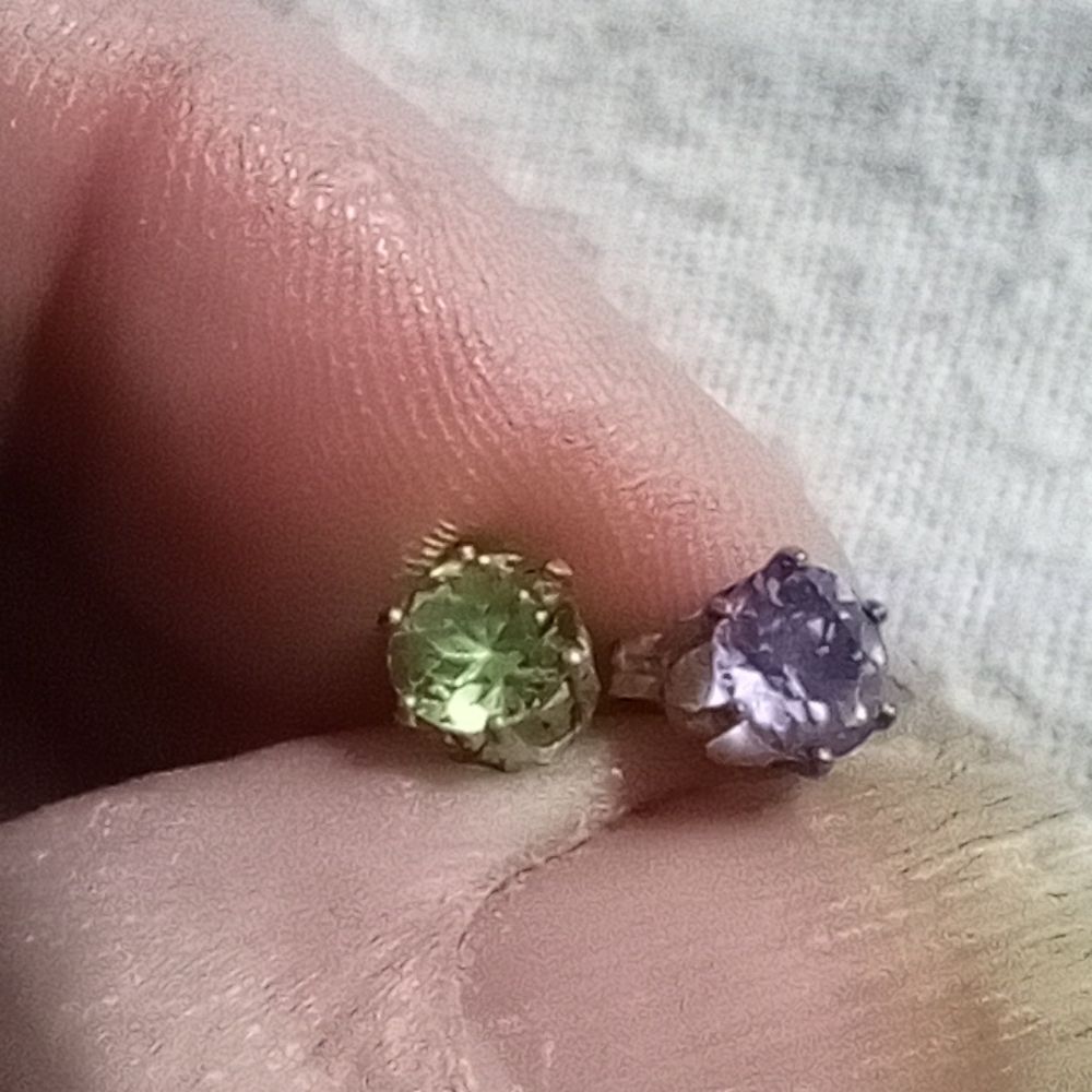 Pierced earrings, one green one purple